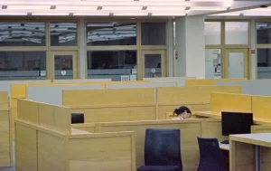 Oficina casi vacía con una persona trabajando sola en su puesto, imagen sobre el burnout o síndrome de estar quemado